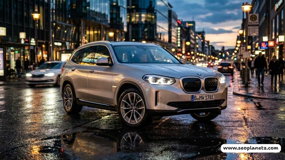 A silver BMW iX3 electric SUV parked on a wet urban road at dusk